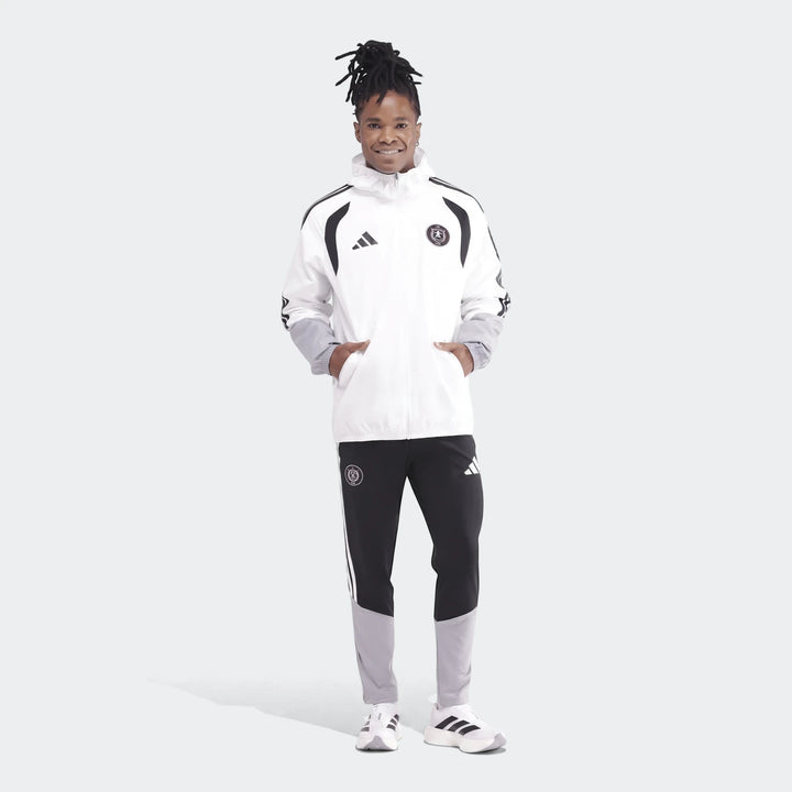 Men's white, black, and grey Adidas Op Tiro26C All Weather Jacket and matching track pants on a model, full body.