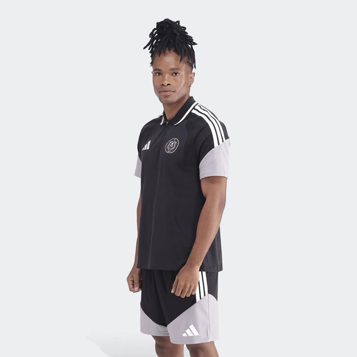 Male model wearing a black and gray Adidas Op Tiro26C Polo shirt and matching shorts, shown in a full body view.