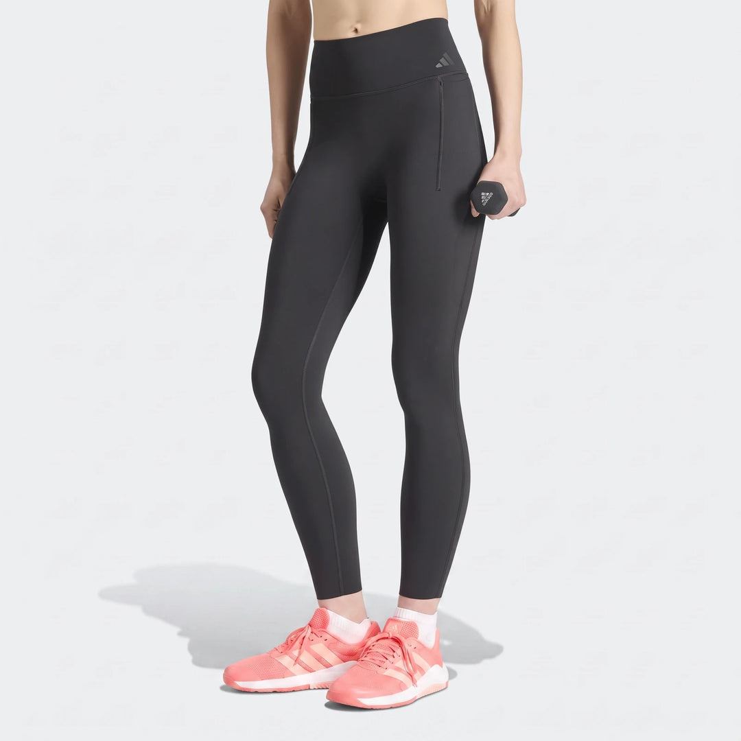 Black Adidas Optime Workout Contour Full Length Leggings worn by a woman holding a dumbbell, showcasing fitness apparel.