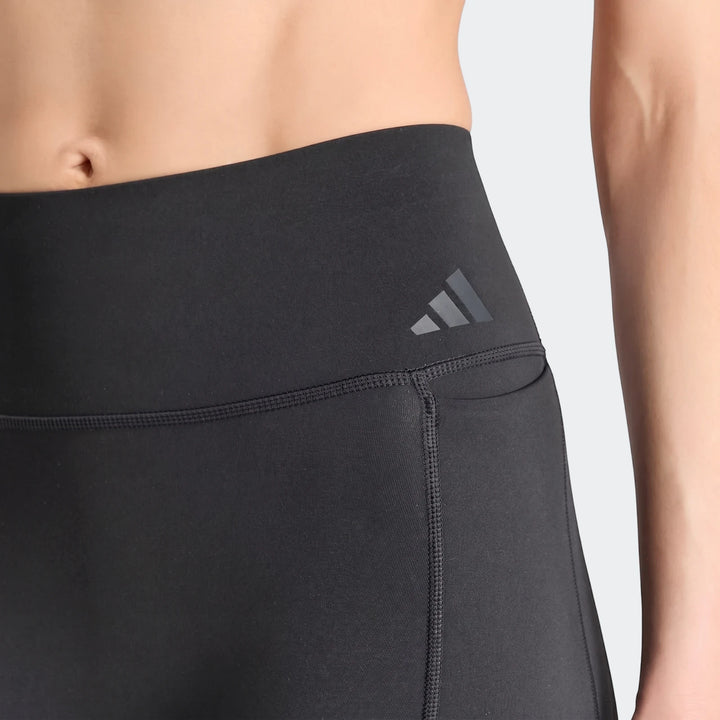 Close-up of black Adidas Optime Workout Contour Full Length Leggings worn by a person, showing the waistline and logo detail.