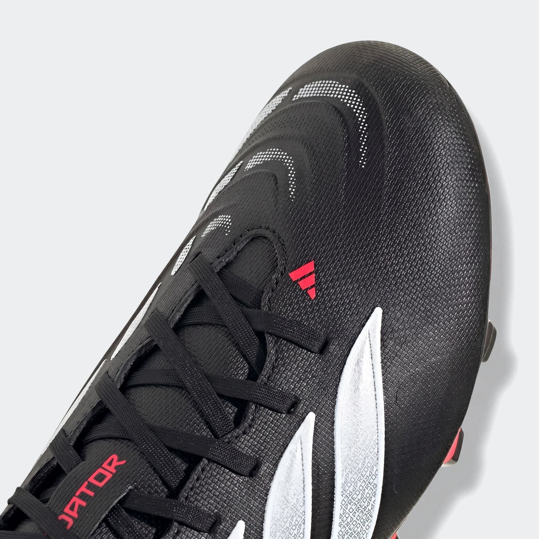 Close-up of a black Adidas Predator Club Firm Ground football boot with white patterns and red accents, featuring textured