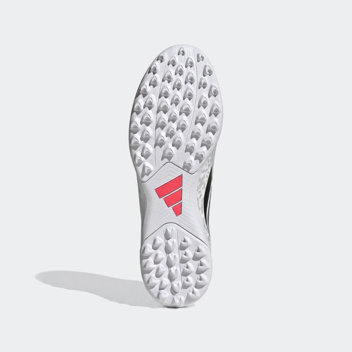 Overhead view of a white Adidas Predator Club Fold-Over Tongue Turf Football Boot sole with red Adidas logo and numerous