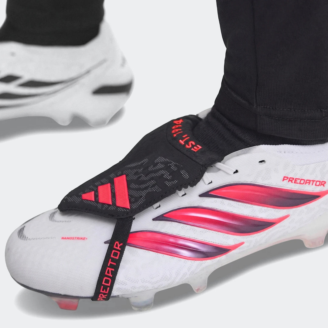 Close-up of white, red, and black Adidas Predator Elite Fold-Over Tongue Firm Ground Football Boots on a foot.