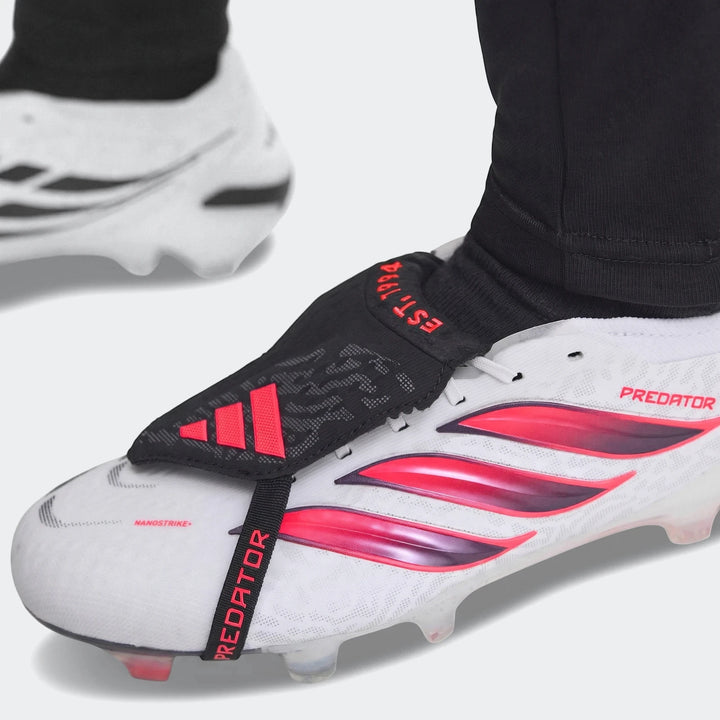 Close-up of white, red, and black Adidas Predator Elite Fold-Over Tongue Firm Ground Football Boots on a foot.