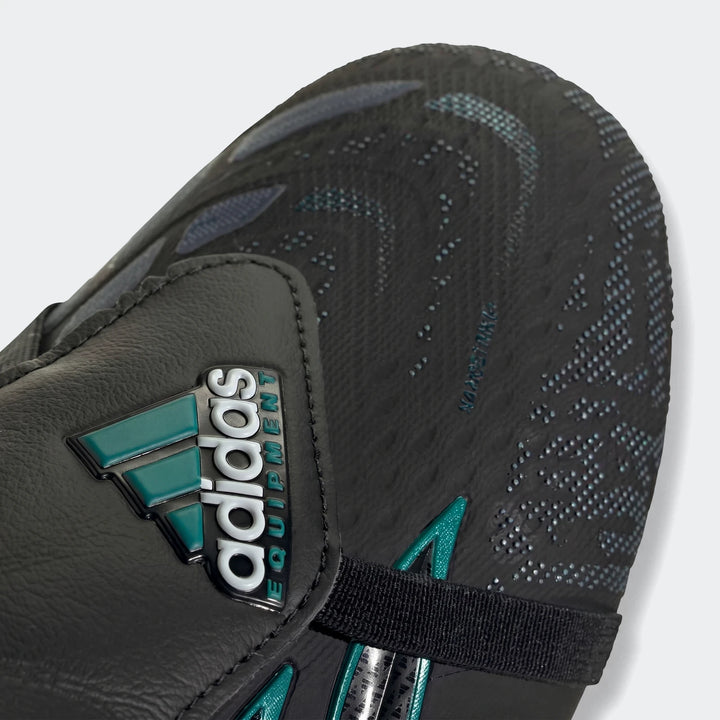 Close-up of a black and teal adidas Predator Elite Ft SG Eqt football boot, featuring the adidas logo and textured upper