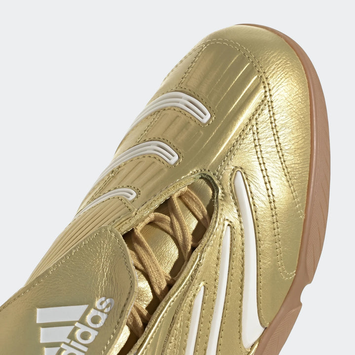 Gold adidas Predator Sala indoor football boot with white stripes and visible laces, close-up view.