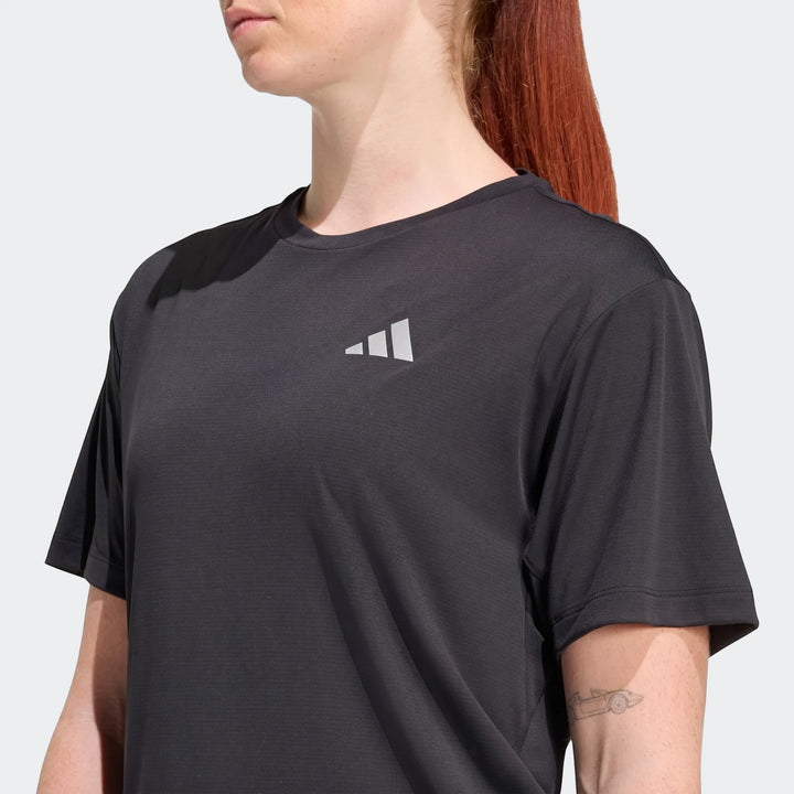 Black Adidas Run Essentials T-Shirt for women, close-up front view on a model, featuring the silver logo on the chest.