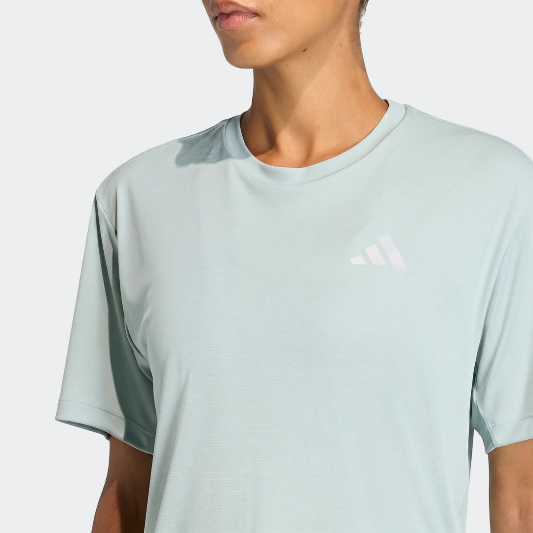 Close-up of model wearing a light blue-green Adidas Run Essentials T-Shirt with white logo.