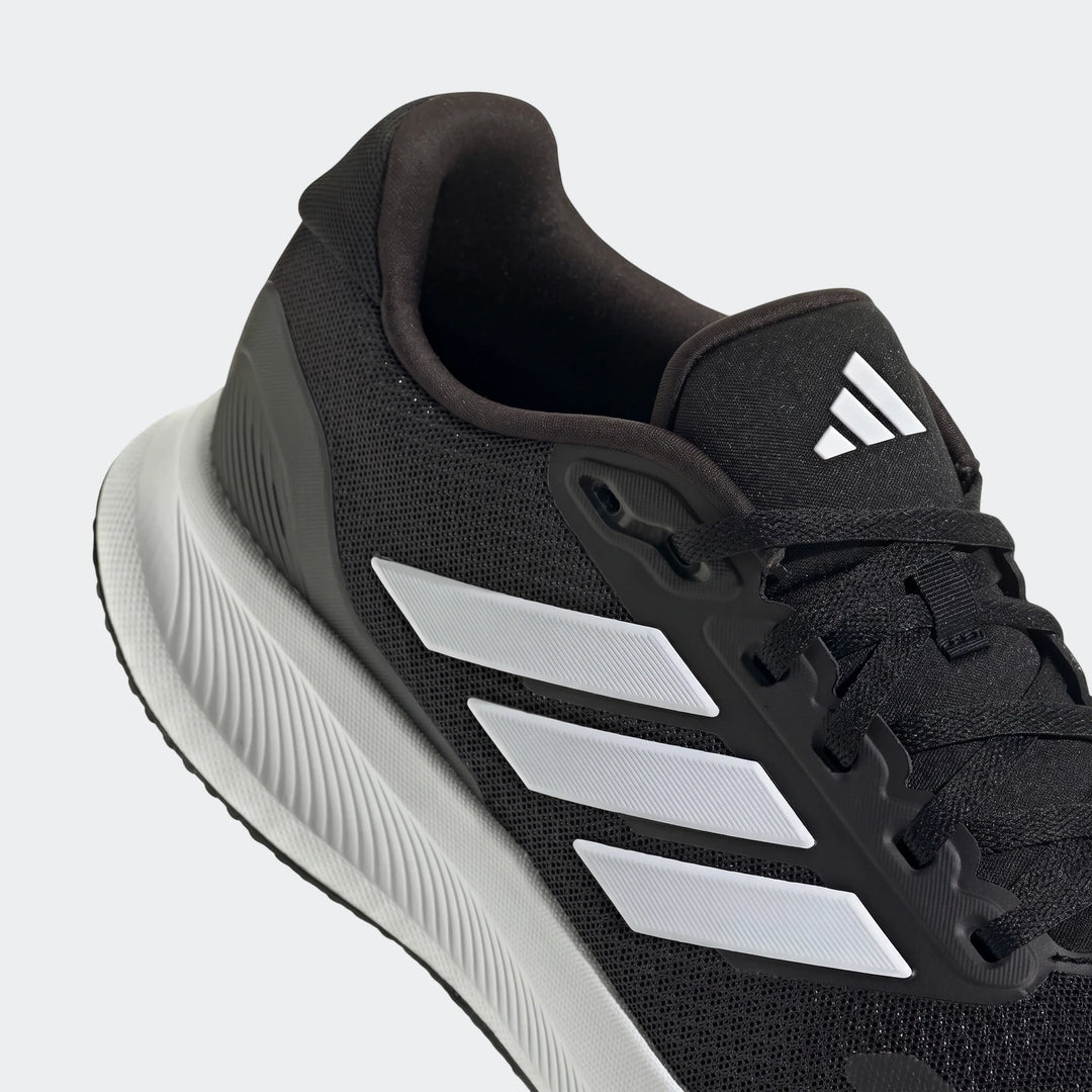 Close-up of a black Adidas Runfalcon 5 running sneaker featuring white iconic three stripes and a white sole.