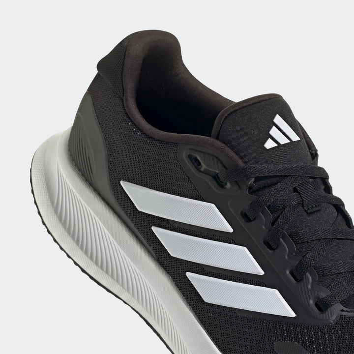 Close-up of a black Adidas Runfalcon 5 running sneaker featuring white iconic three stripes and a white sole.