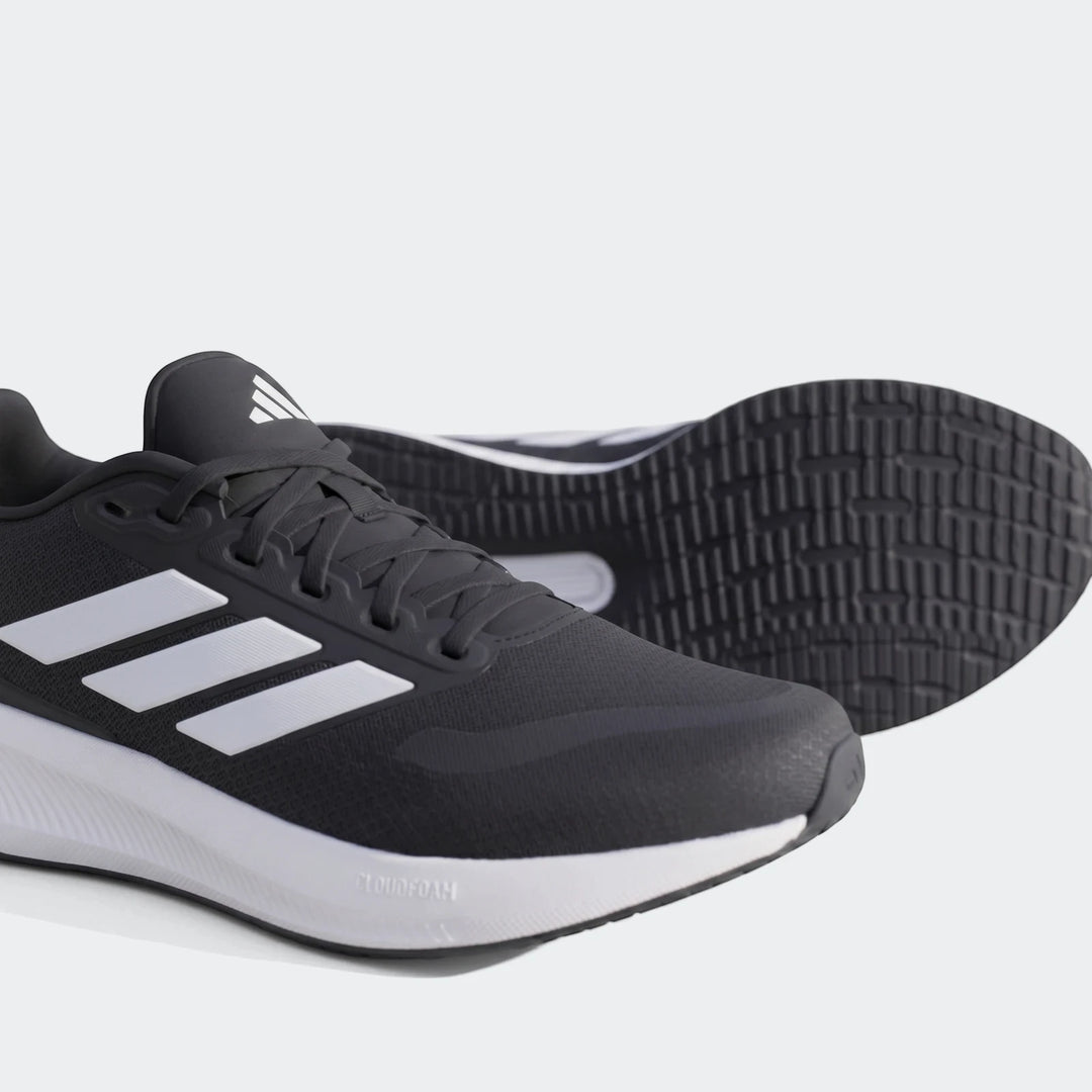 Pair of black Adidas Runfalcon 5 sneakers with white stripes and Cloudfoam midsole, positioned on a concrete surface.