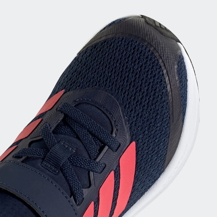 Close-up view of a dark blue and red mesh Adidas Runfalcon 6 children's shoe, featuring prominent red stripes and black