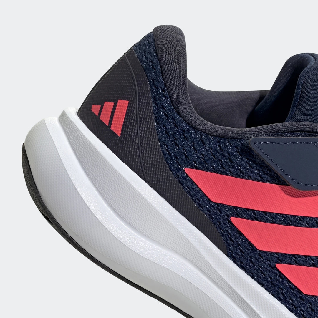 Close-up of a child's navy blue Adidas Runfalcon 6 shoe featuring red stripes and a white midsole.