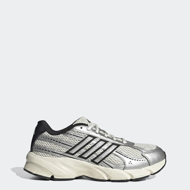Adidas running shoe in silver, white, and black with a mesh upper and chunky sole, displayed from the side.