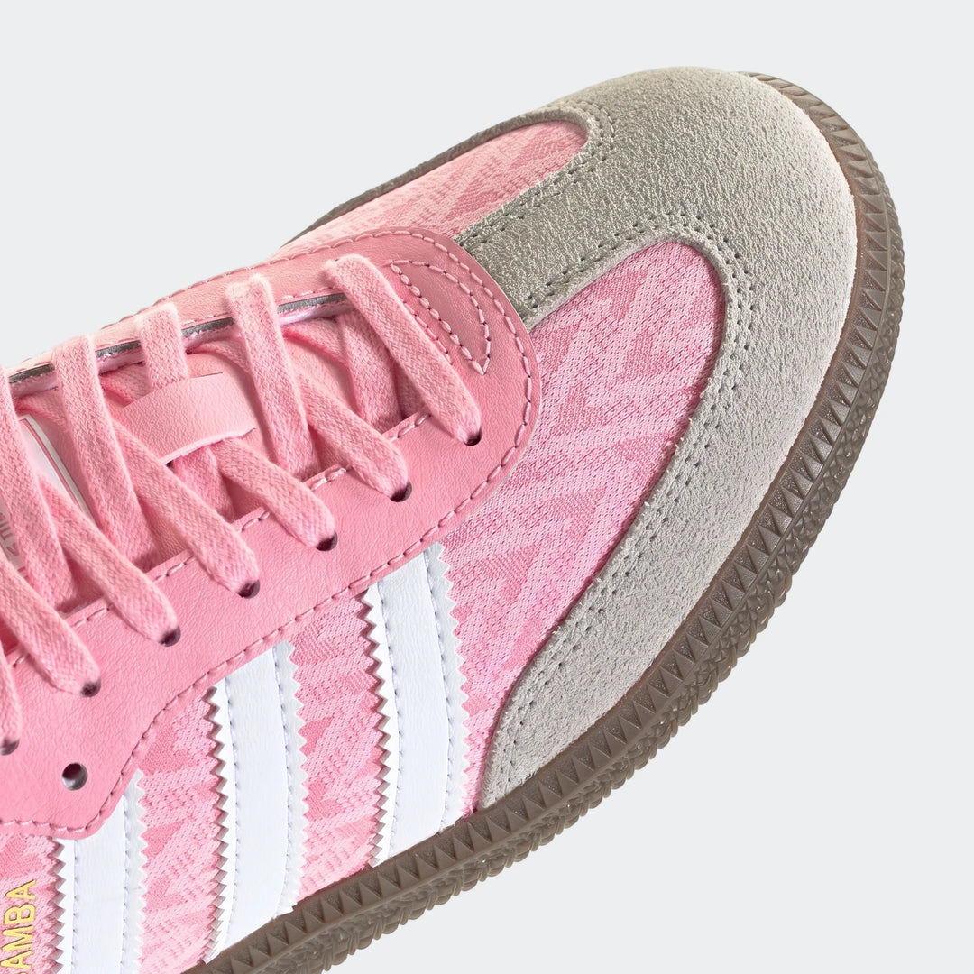 Close-up of pink Adidas Samba Og Kids Shoes, showcasing the patterned textile upper, grey suede overlays, white stripes, and