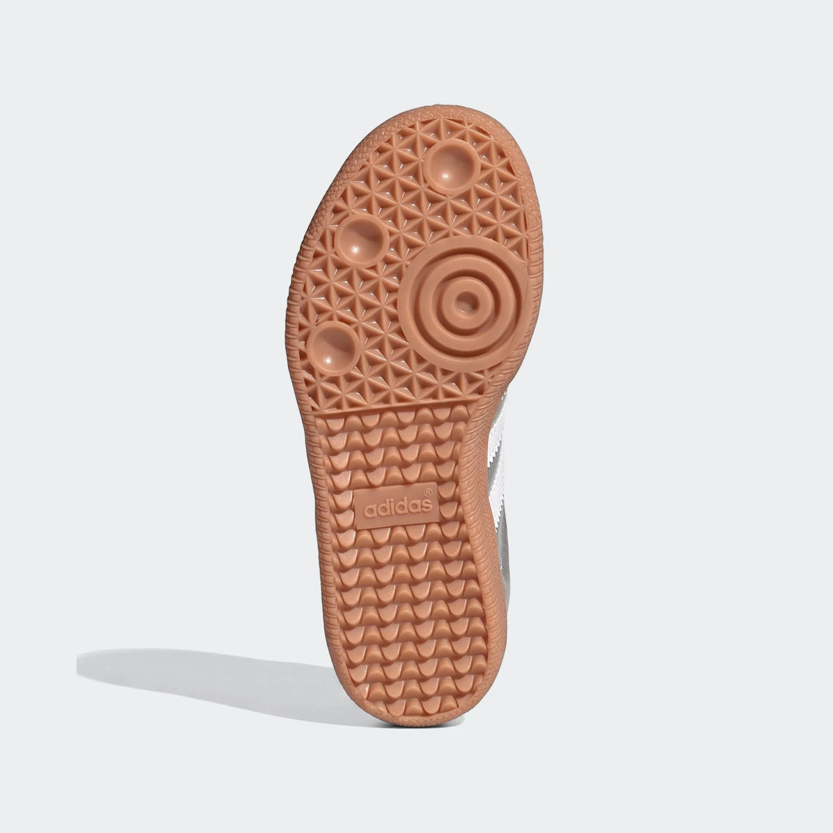 Bottom view of an Adidas Samba OG shoe, featuring a textured gum sole with the brand logo and white side stripes.