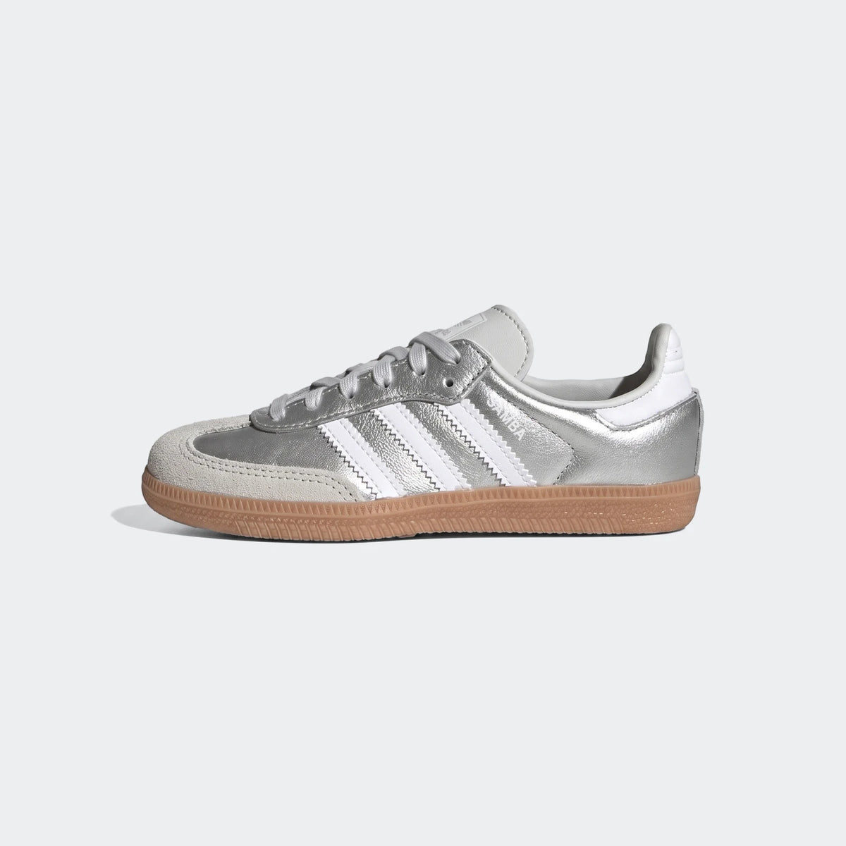 Adidas Samba OG shoes in silver metallic with white stripes and a brown gum sole, presented in a side view.