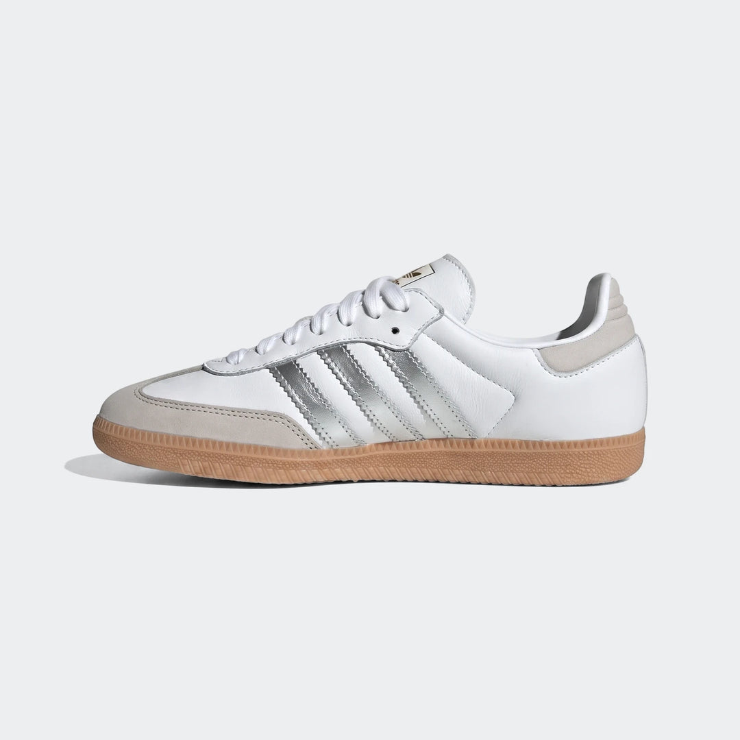 White Adidas Samba OG shoes with silver stripes and gum sole, presented in a clean side profile view.