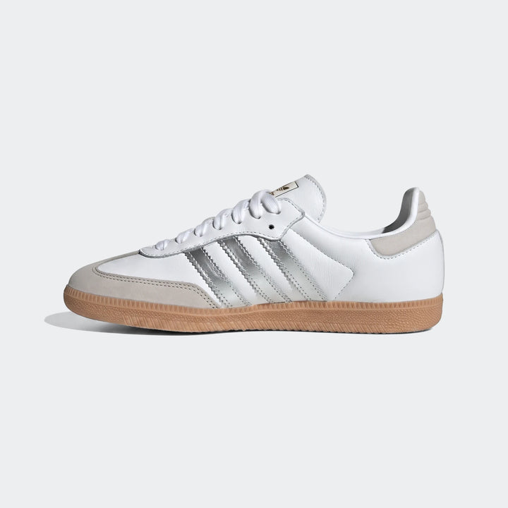 White Adidas Samba OG shoes with silver stripes and gum sole, presented in a clean side profile view.