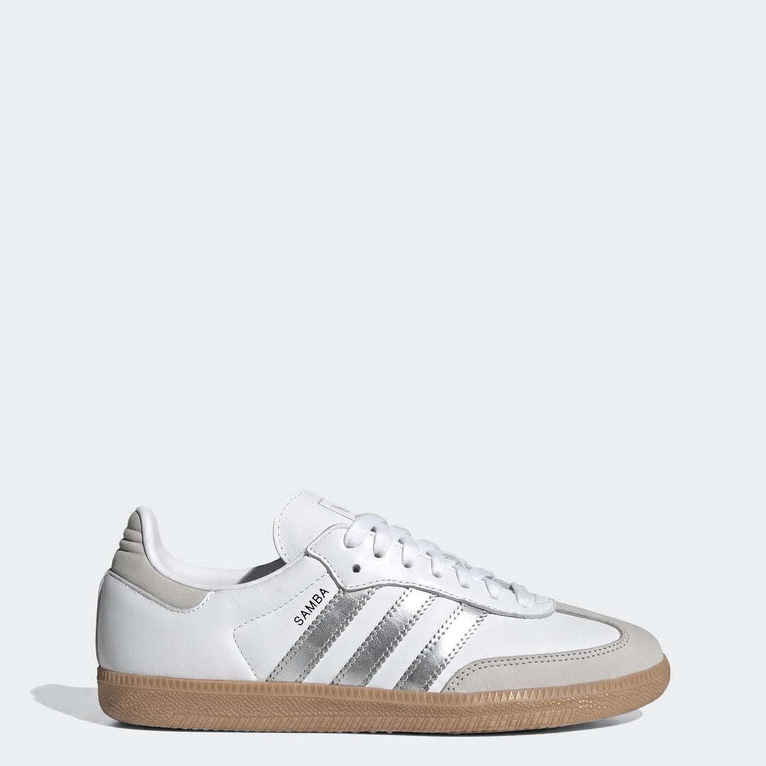 White Adidas Samba Og shoes feature a leather upper, iconic silver three-stripes, and a tan gum sole, presented in a clean