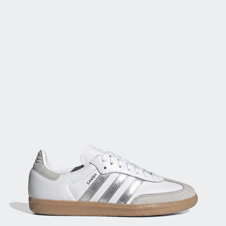 White Adidas Samba Og shoes feature a leather upper, iconic silver three-stripes, and a tan gum sole, presented in a clean