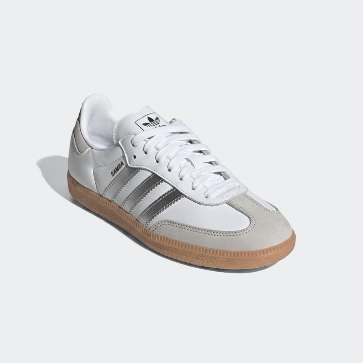 Adidas Samba Og shoes in white leather with silver stripes and a gum sole, shown from an angled view.