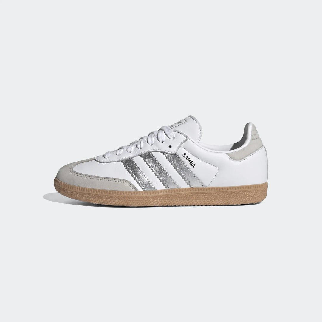 Adidas Samba Og men's sneakers in white leather with silver stripes and a tan gum sole, shown from the side.