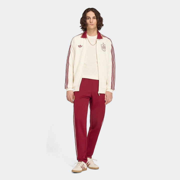 Male model wearing an off-white and maroon Adidas Spain Away Anthem Jacket and matching tracksuit.
