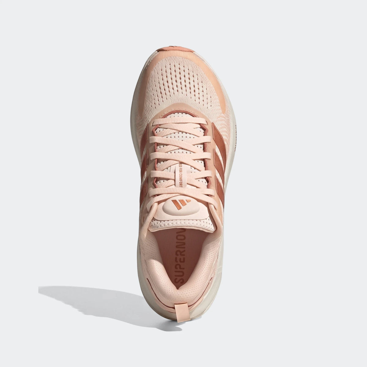 Top-down view of Adidas Supernova Ease 2 women's running shoes in a light pink/peach color with rose gold stripes.
