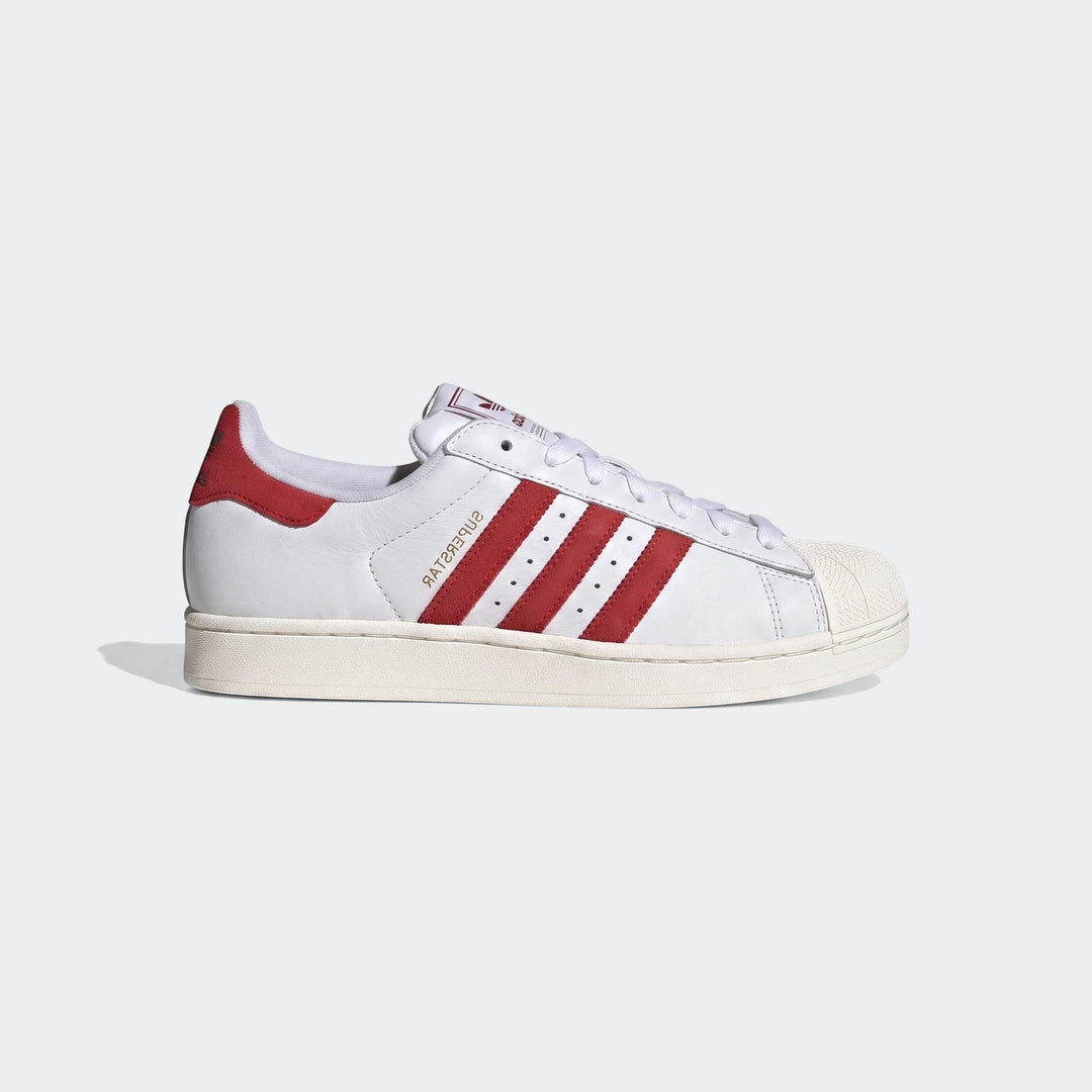 A pair of white Adidas Superstar II low-top shoes with bold red three stripes and heel tab, shown in a side view.