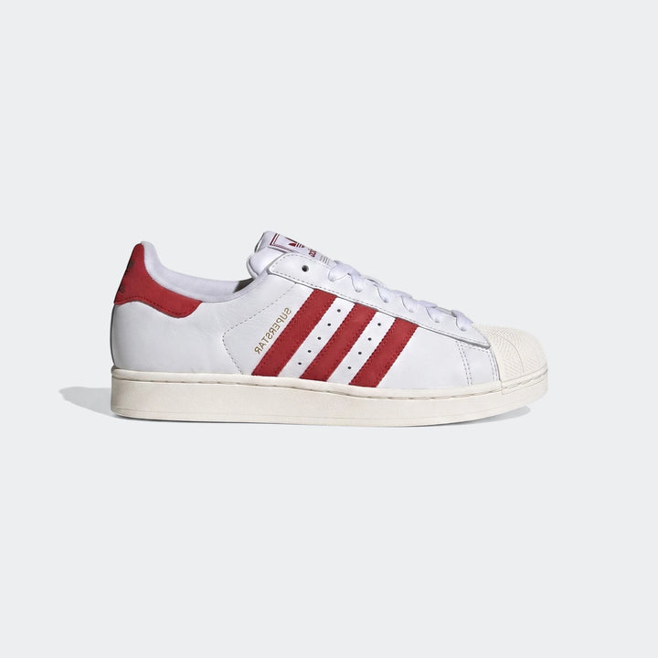 A pair of white Adidas Superstar II low-top shoes with bold red three stripes and heel tab, shown in a side view.