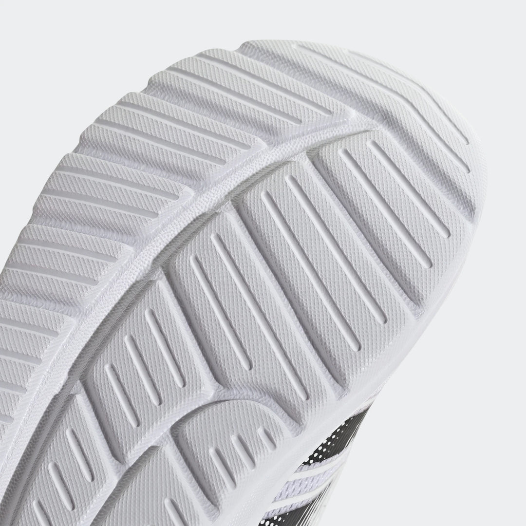 Close-up of a white and black Adidas Tensaur Run 4.0 Infants shoe sole, showcasing its textured tread pattern.