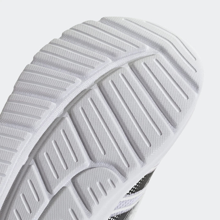 Close-up of a white and black Adidas Tensaur Run 4.0 Infants shoe sole, showcasing its textured tread pattern.