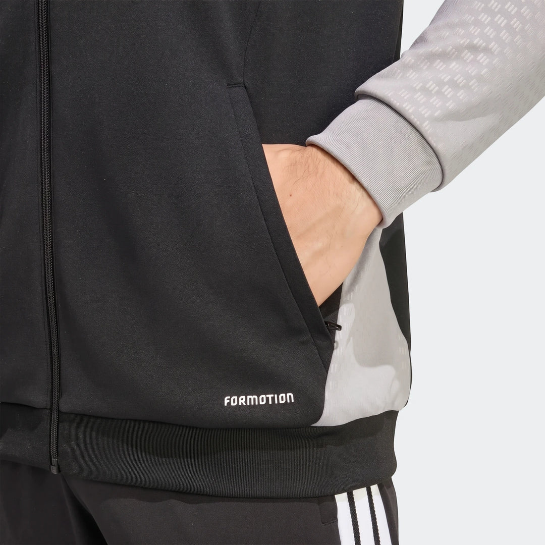 Close-up of a black and gray Adidas Tiro 26 Competition Training Jacket, worn by a person with their hand in the pocket.