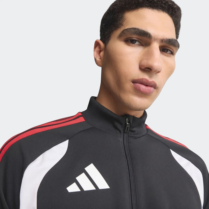 Close-up of a male model wearing an Adidas Tiro 26 Competition Training Jacket in black with red stripes and white panels,