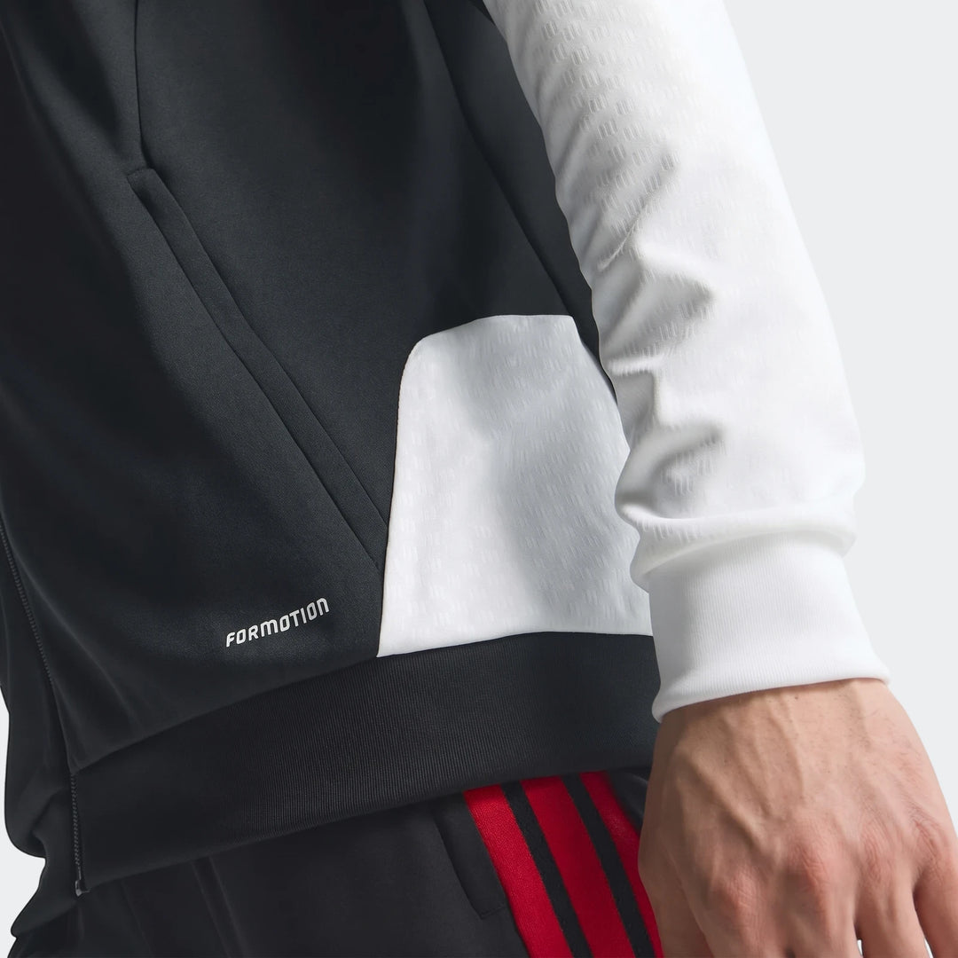 Close-up of a person wearing a black and white Adidas Tiro 26 Competition Training Jacket with FORMOTION logo, paired with