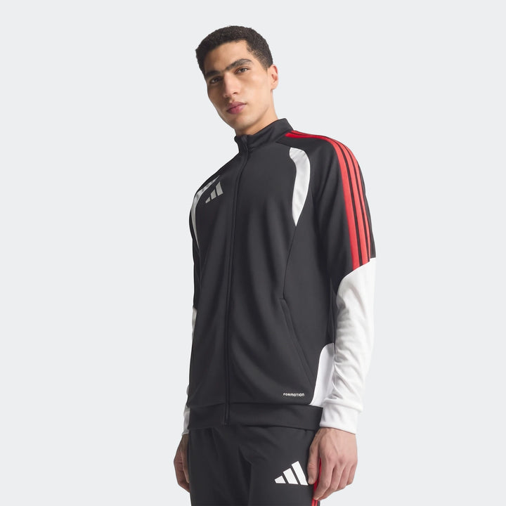 Male model wearing a black, red, and white Adidas Tiro 26 Competition Training Jacket, standing with arms down, shown from