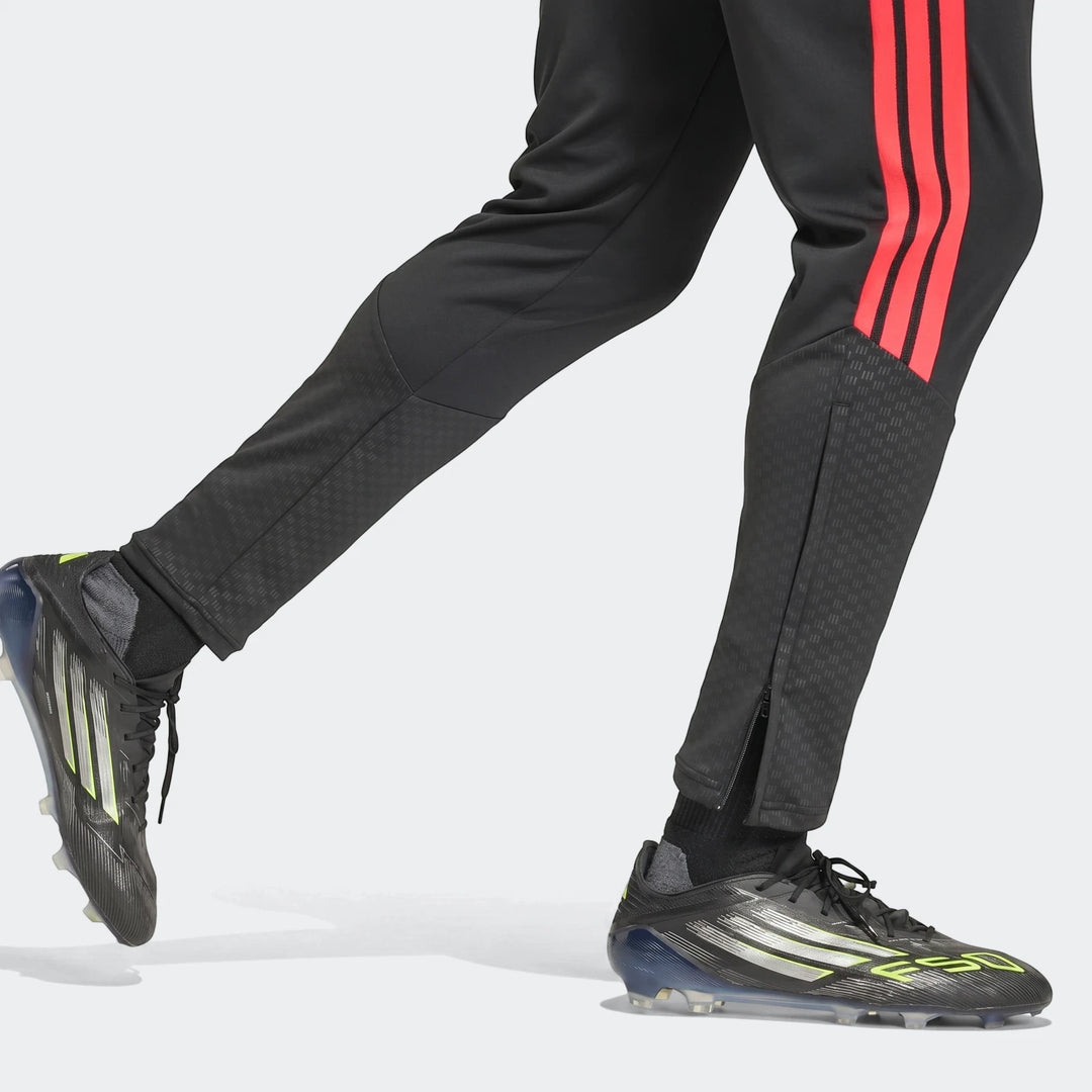 Black Adidas Tiro 26 Competition Training Pants with red stripes and black soccer cleats with silver and yellow accents.