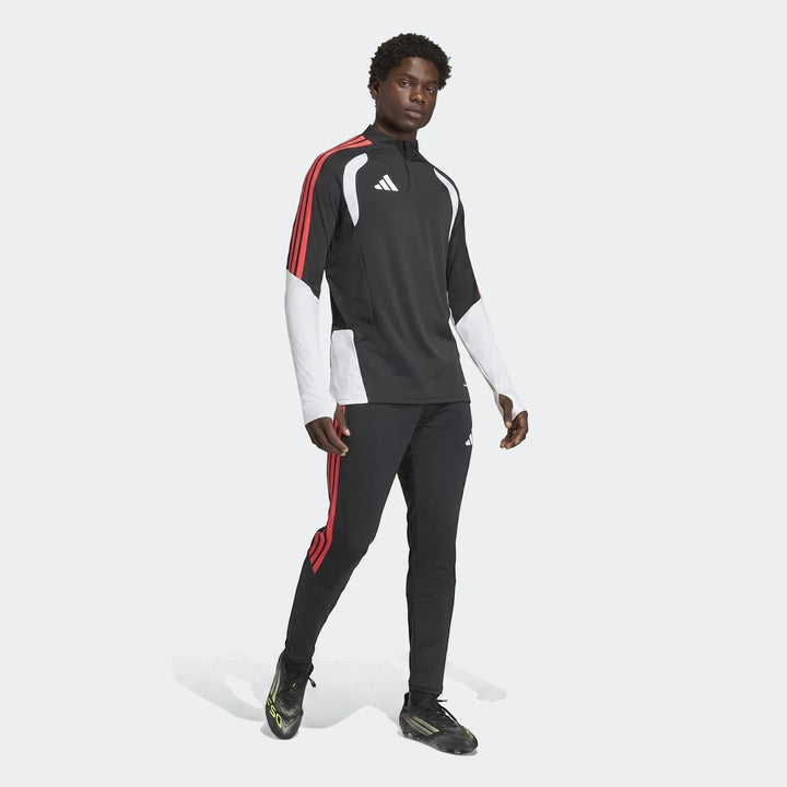 Male model wearing black Adidas Tiro 26 Competition Training Pants with red stripes, a matching training jersey, and black