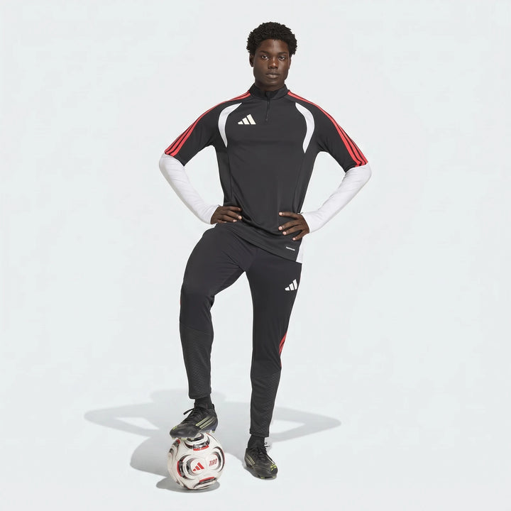 Male model in black Adidas Tiro 26 Competition Training Pants and top with white arm sleeves, standing with a football.