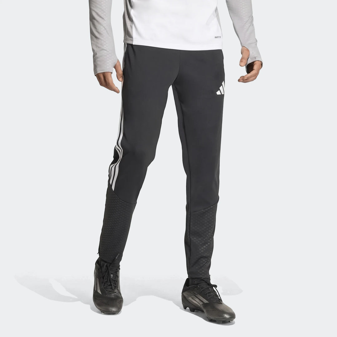 Men's black Adidas Tiro 26 Competition Training Pants, featuring white stripes and logo, worn by a model with black cleats.
