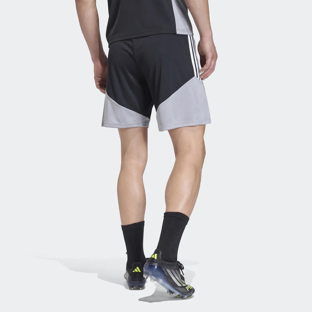 Male model wearing black and grey Adidas Tiro 26 Competition Training Shorts, black socks, and cleats, shown from a rear