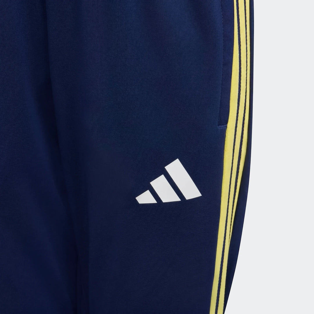 Close-up of Adidas Tiro 26 Competition Youth Training Pants in dark blue with bright yellow three-stripe branding and white