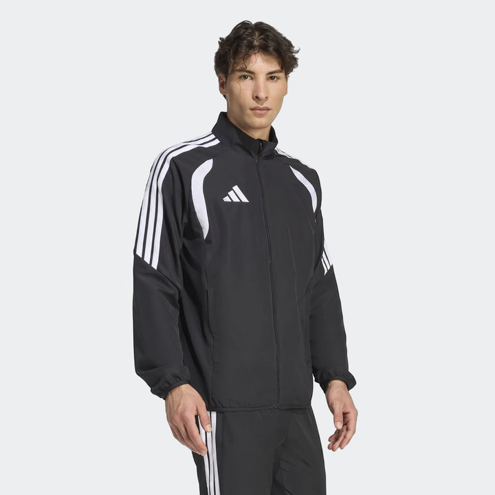 Male model wearing a black Adidas Tiro 26 League Presentation Jacket with white shoulder stripes and a full-zip front.