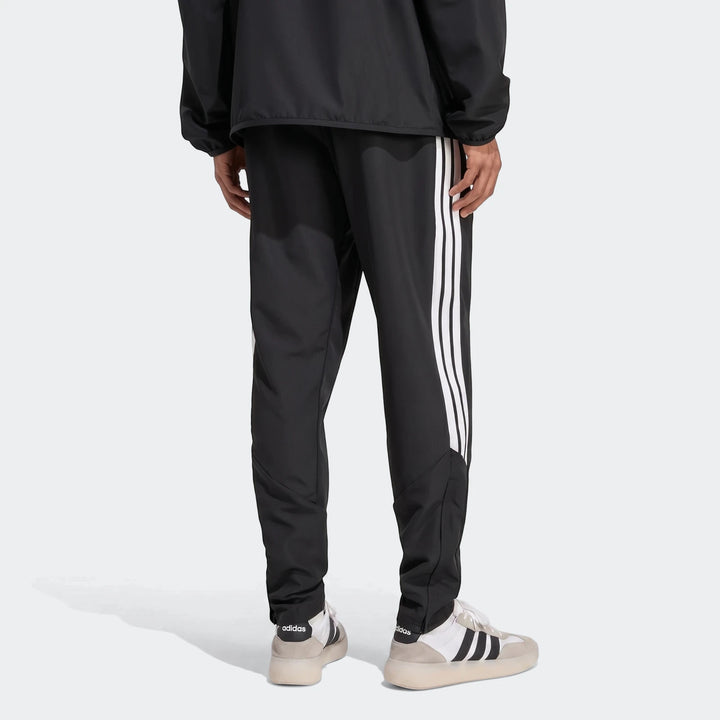 Black Adidas Tiro 26 League Presentation Pants with white 3-stripes, worn by a person seen from the back, showcasing the