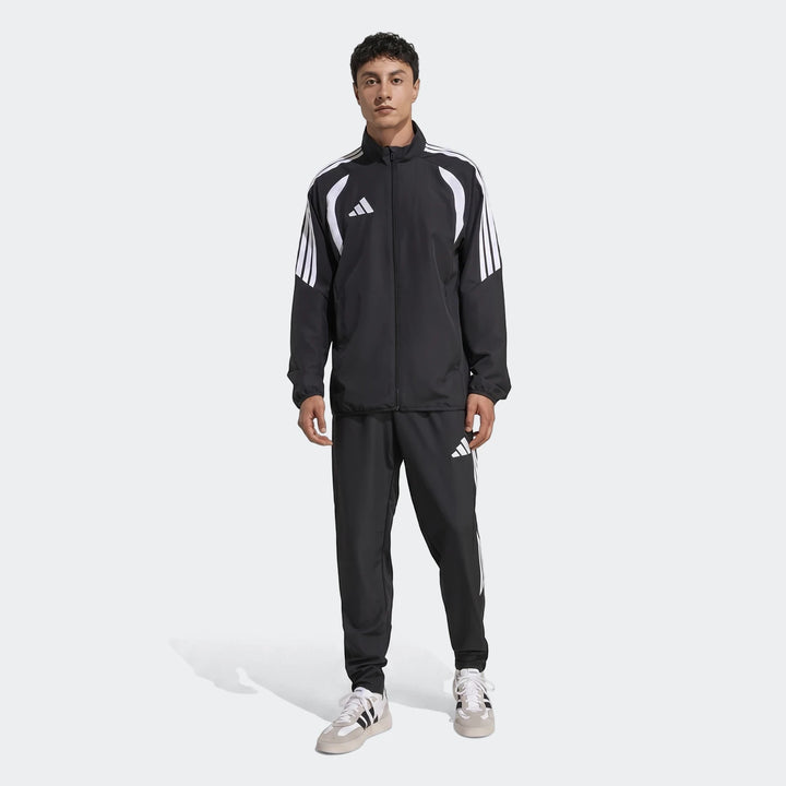 Full length shot of a man wearing a black Adidas Tiro 26 League Presentation tracksuit with white stripes and logos.