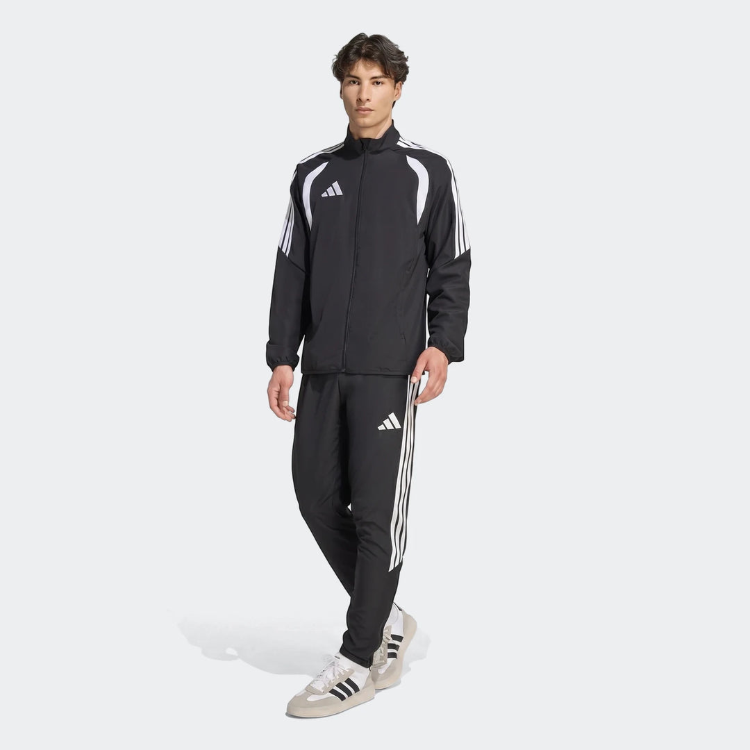Full body shot of a male model wearing a black Adidas Tiro 26 League Presentation Jacket and matching track pants,