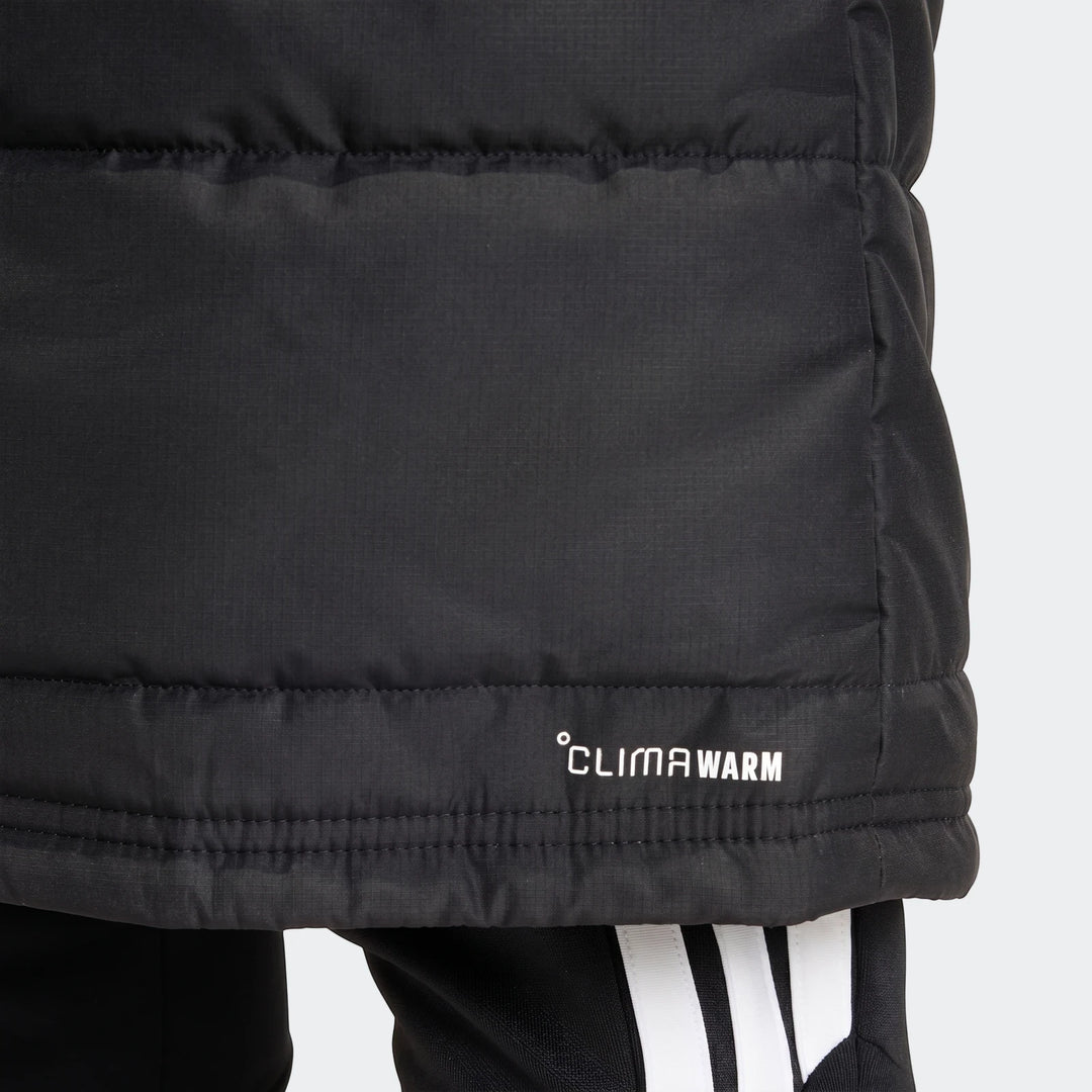 Black adidas Tiro 26 Long Coat, a warm puffer jacket featuring the CLIMAWARM logo, shown worn with black adidas track pants.