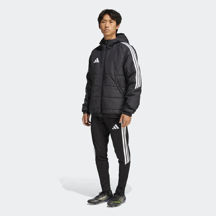 Full-body shot of a male model wearing a black Adidas Tiro 26 Windbreaker Jacket with white three stripes and matching track
