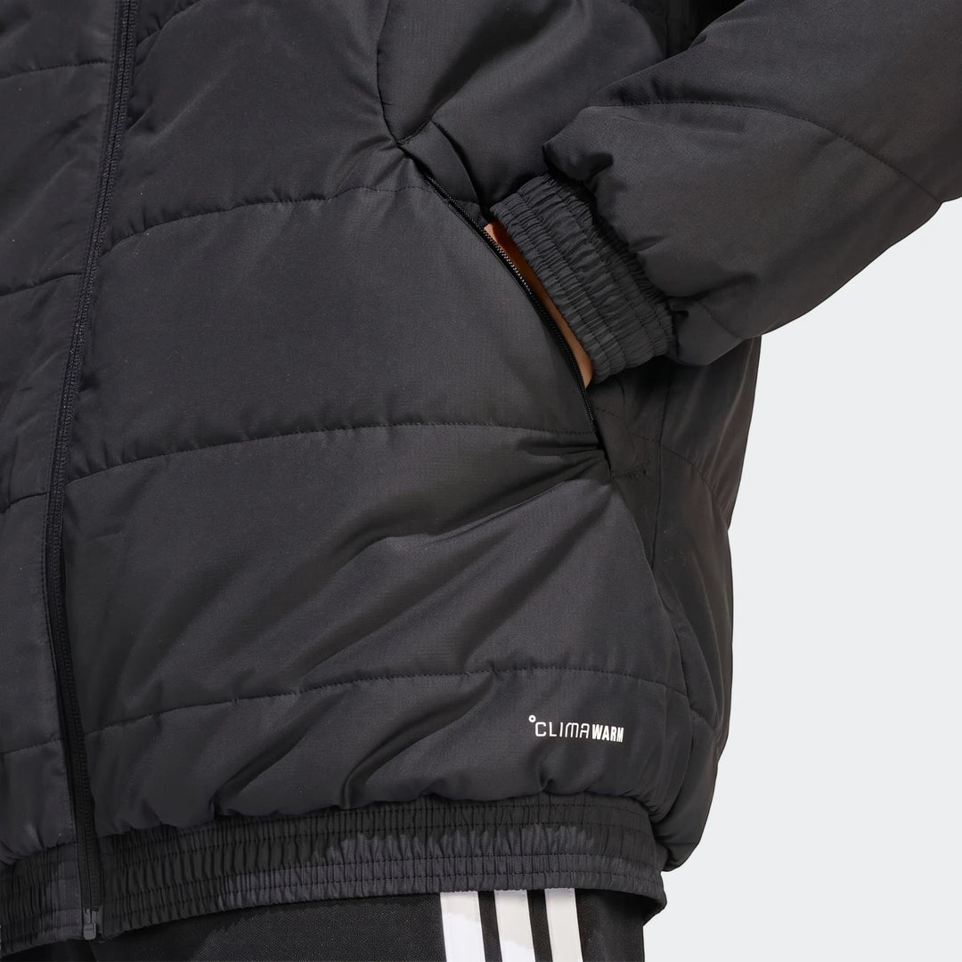 Close-up of a black quilted Adidas Tiro 26 Windbreaker Jacket, with a hand in the pocket and "CLIMAWARM" logo visible.